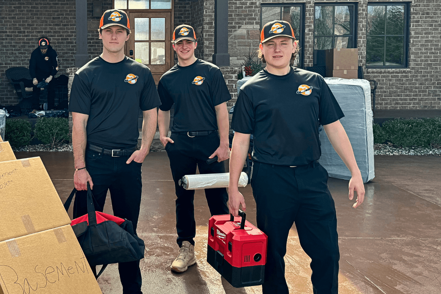 Extra Mile Moving crew in uniform posing with their tools
