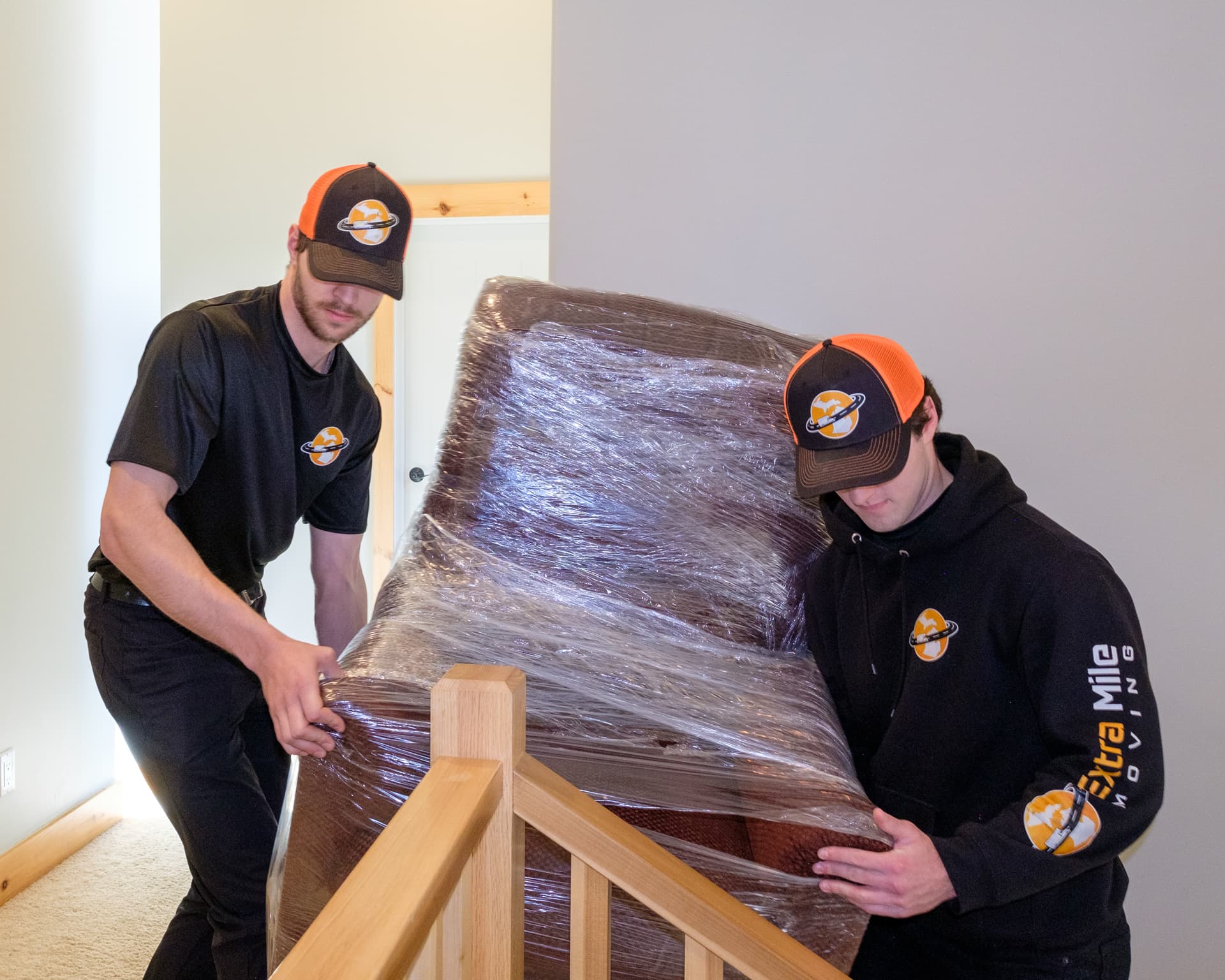 Movers carrying furniture up apartment stairs