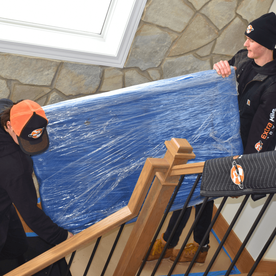 Movers carrying an item down protected stairs
