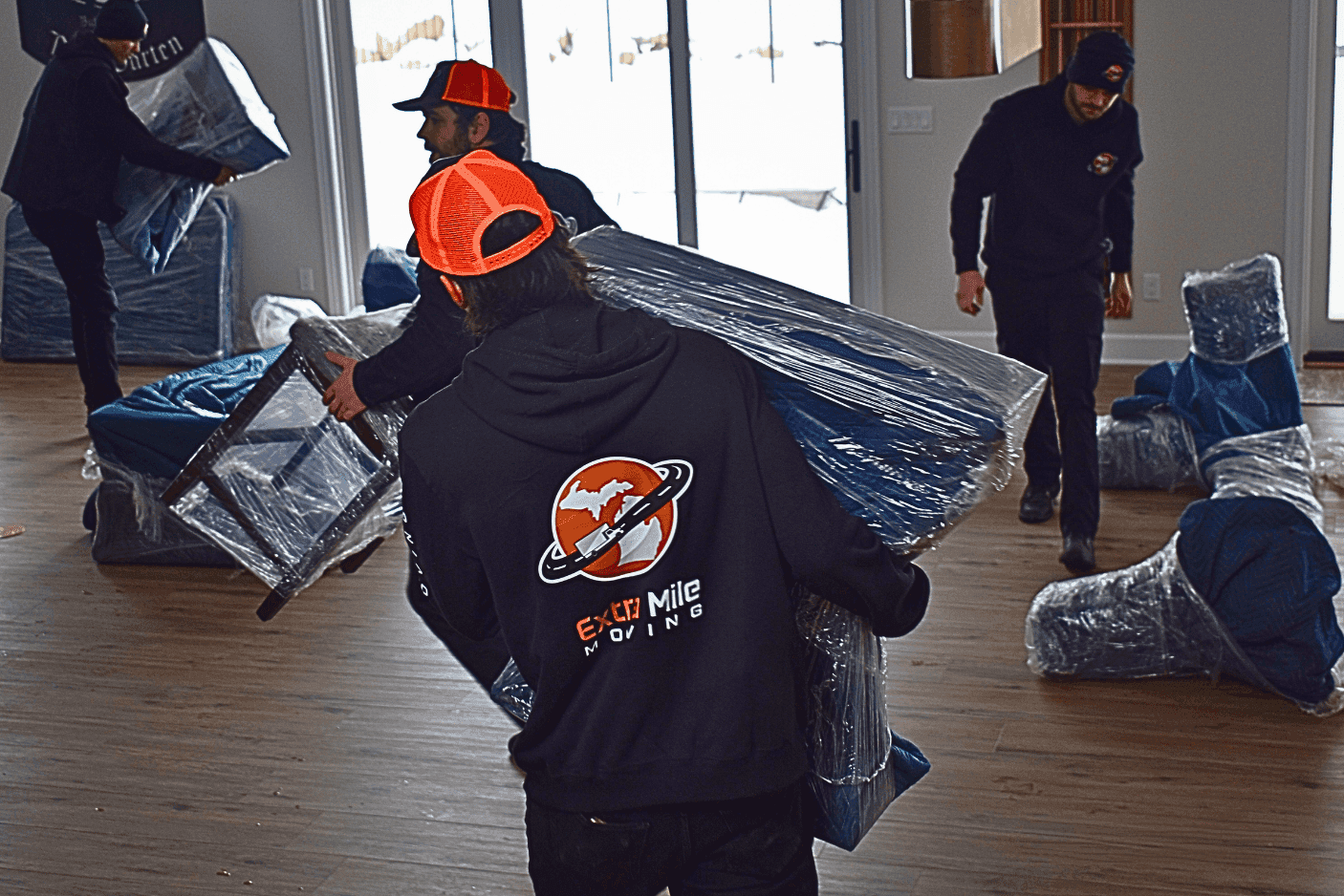 Movers carrying protected furniture through a home